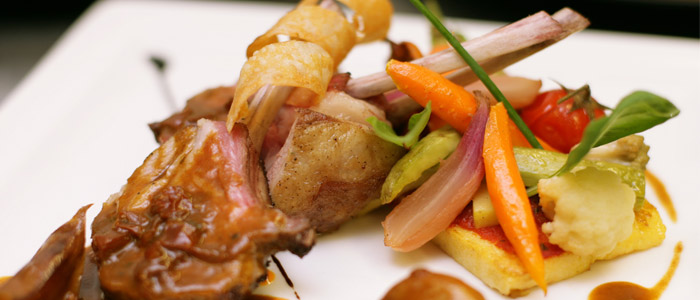 Carré d’agneau du Quercy roti, légumes glacés à l’huile d’olives Taggiashes, polenta  et  jus aux délices de tomates  séchées
